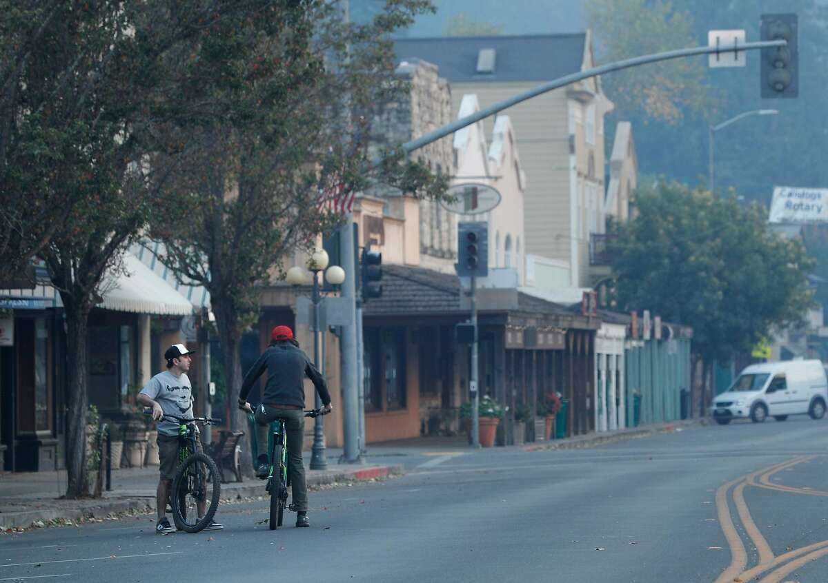 Ali Pehzadpour, left, talks in an abandoned downtown Calistoga, with Marshall Hayman, right, who lost home to the fire, after a mandatory evacuation was called for the entire town in Calistoga, Calif., on Wednesday, October 11, 2017. The Napa and Sonoma valleys continue to be under threat from several fires not yet under control and growing fears that strong winds might worsen the situation.