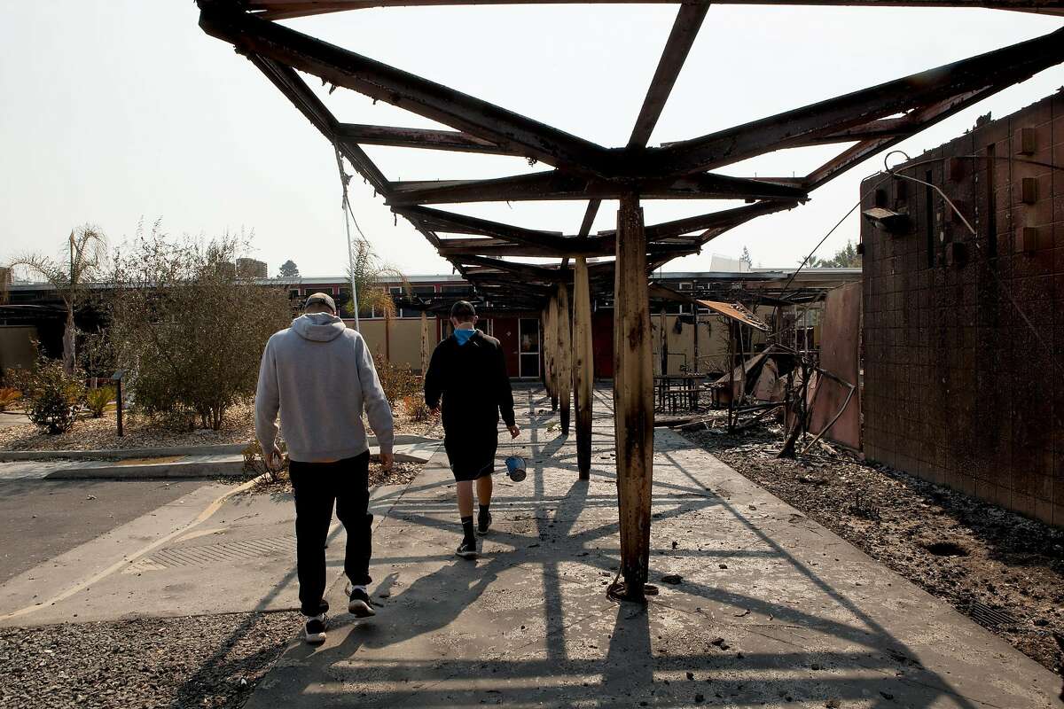 Seniors Tyler Botteri and Deric Younce (left to right) look through the damage Tubbs Fire inflicted on Cardinal Newman High School in Santa Rosa, Ca. on Wednesday, October 11, 2017. Both boys are athletes at the school.