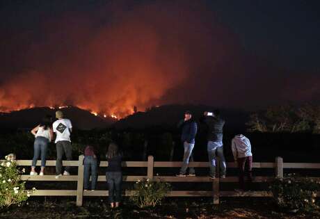 Members of the community watch as a fire grows along the ridge near Highway 12 outside Eldridge, Calif., on Tuesday, October 10, 2017. Sonoma Valley continues to be under threat from several fires as some communities begin to assess the impact of the fires.