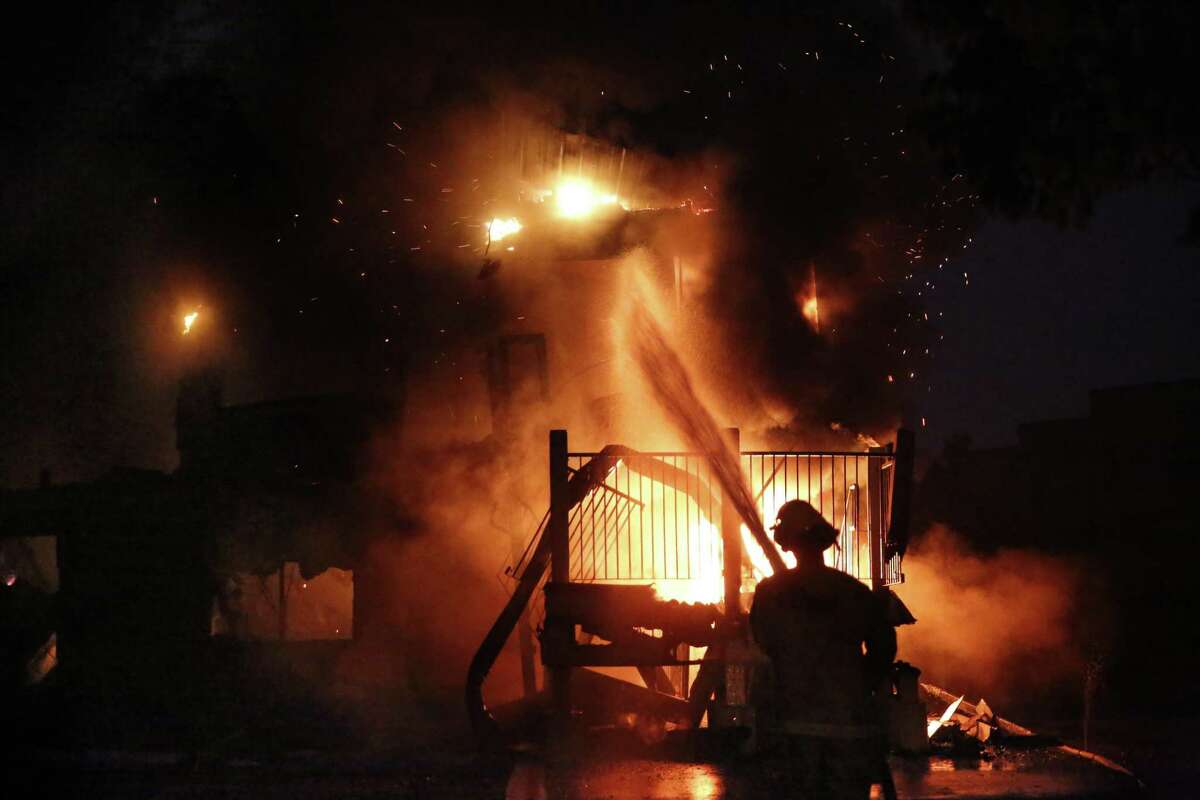 A firefighter with Cal Fire pours water onto the America's Best Value Inn along Cleveland Ave. which is a total loss in the fire, in Santa Rosa, Ca., on Monday October 9, 2017. Massive wildfires ripped through Napa and Sonoma counties early Monday, destroying hundreds of homes and businesses on Monday October 9, 2017