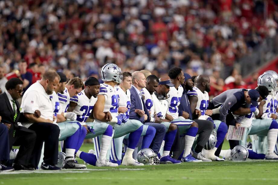 24 de setembro de 2017 - Mais de 200 jogadores se ajoelharam em resposta aos tweets de Trump. Acima, os membros do Dallas Cowboys unem os braços e se ajoelham durante o Hino Nacional antes do início da NFL, no dia seguinte, em Glendale, Arizona. Foto: Christian Petersen / Getty Images