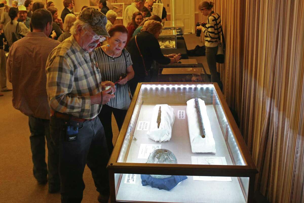 Don Mathis and Patricia Seidenberger check out artifacts at the Alamo, Thursday. The artifacts were among 150 items on display — most for the first time to the public — as part of a one-day exhibition in celebration of Texas Archeology Month. In the case are clockwise from top left, a Brown Bess India Pattern Musket bayonet, a First Pattern Rifle Baker Rifle barrel and a unfired 7” Howitzer shell.