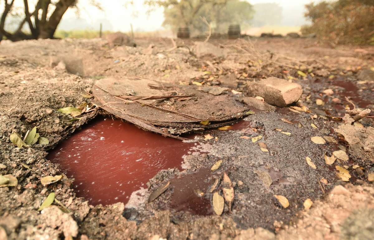 A boiling river of wine flows underneath smoldering debris at the Paradise Ridge Winery in Santa Rosa, California on October 10, 2017. Firefighters battled wildfires in California's wine region on Tuesday as the death toll rose to 15 and thousands were left homeless in neighborhoods reduced to ashes.