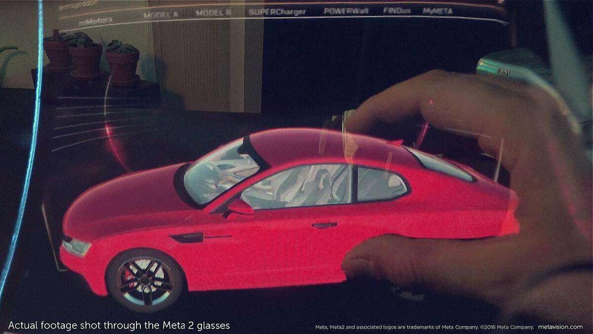 This photo shot through the lenses of San Mateo startup Meta's second-generation augmented reality glasses prototype depicts how an automobile designer can view a digital car design.
