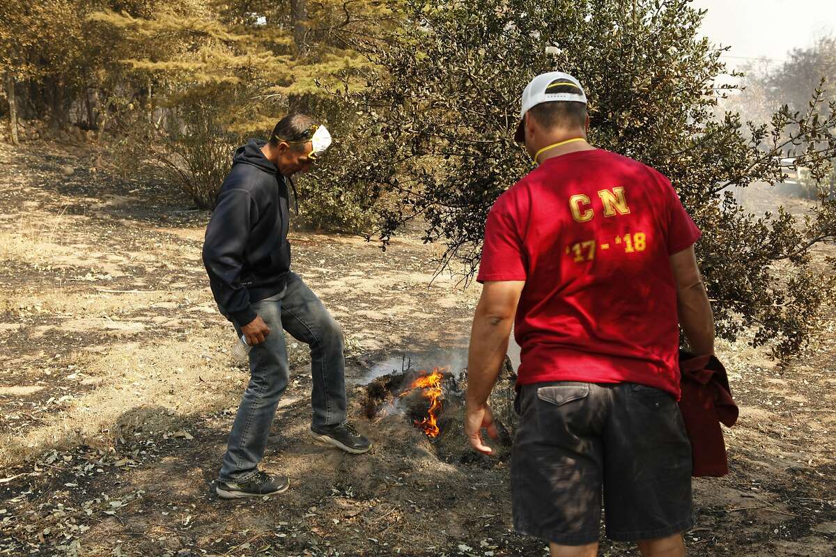 John Gilson and Derek DeBendetti (left to right) try to put out a hot spot at Cardinal Newman High School in Santa Rosa, Ca. on Wednesday, October 11, 2017. Gilson is Dean of Students at Cardinal Newman as well as the Varsity Women's Soccer coach and Freshman Baseball coach. DeBanedetti is a math teacher at Cardinal Newman and the Varisty Baseball Coach. The school suffered major damages in the Tubbs Fire.