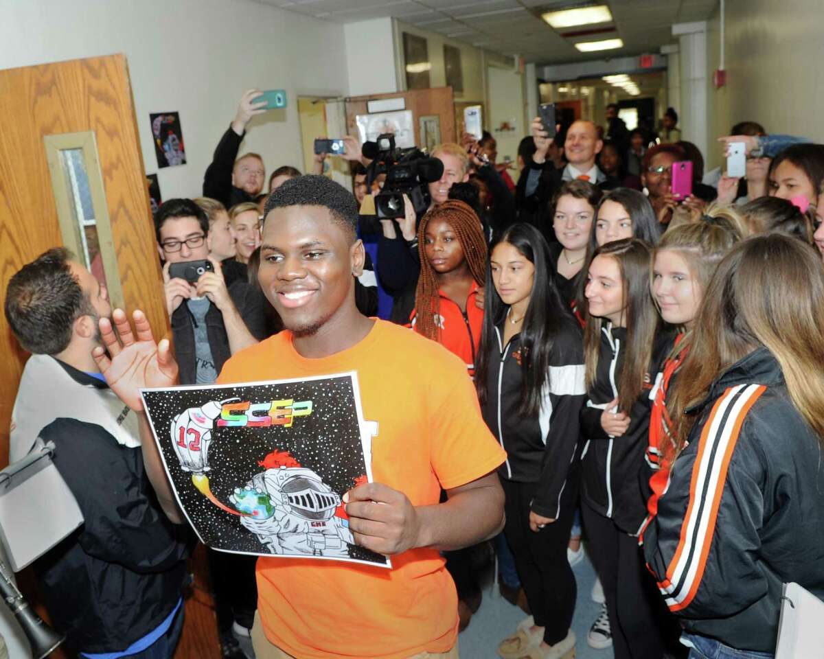 Surprise celebration at Stamford High School, Conn., Friday, Oct. 13, 2017, to honor Stamford High School senior Krantz Medeus, 17, at center waving holding the NASA patch that he designed that was selected as a district-wide contest winner that will be sent to the Johnson Space Center and flown into space to be used affixed to astronauts uniforms.
