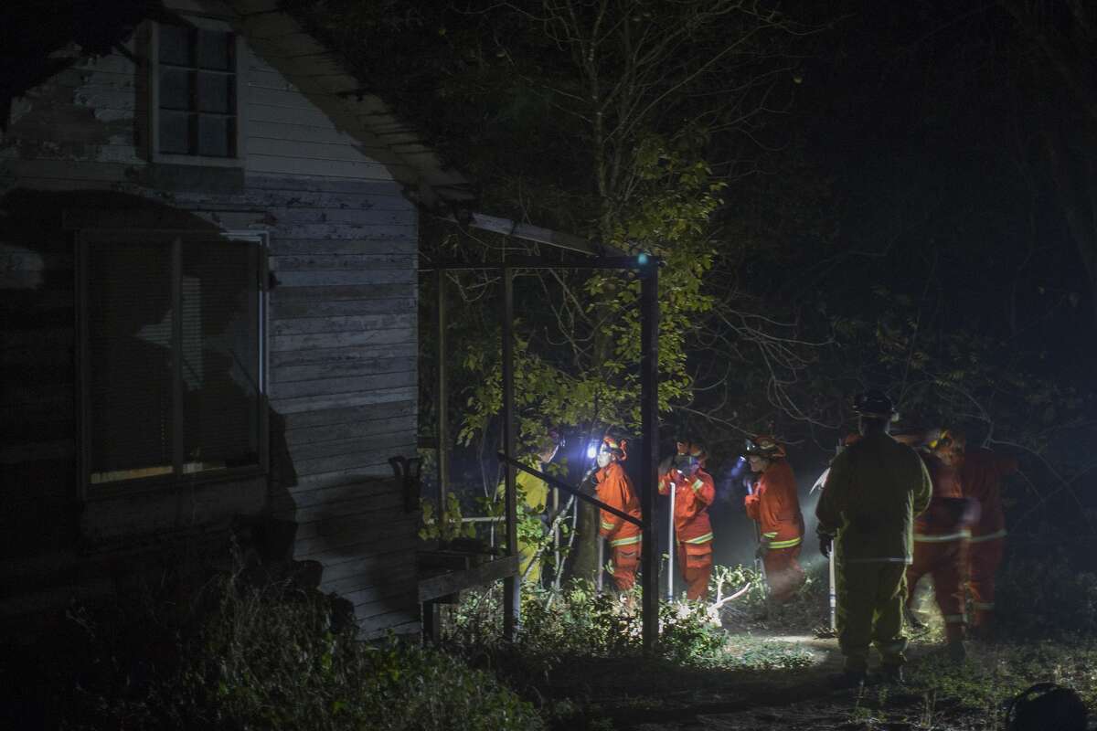 The Puerta la Cruz female inmate firefighter crew clears vegetation near homes in Dry Creek Canyon to try to save them as the Partrick Fire approaches on October 12, 2017 west of Napa, California. Inmate hand crews work under the supervision of Cal Fire, which refers to them as firefighters rather than prisoners because they perform the same job as the elite Hot Shot firefighter crews. Thousands of homes have burned, at least 31 people confirmed killed with hundreds still missing as California wildfires continue to spread out of control. (Photo by David McNew/Getty Images)