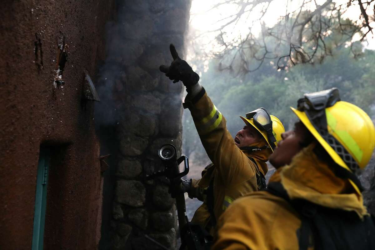 Firefighters try to extinguish a house fire during the Tubbs Fire on October 12, 2017 near Calistoga, California. At least thirty one people have died in wildfires that have burned tens of thousands of acres and destroyed over 3,500 homes and businesses in several Northern California counties. (Photo by Justin Sullivan/Getty Images)