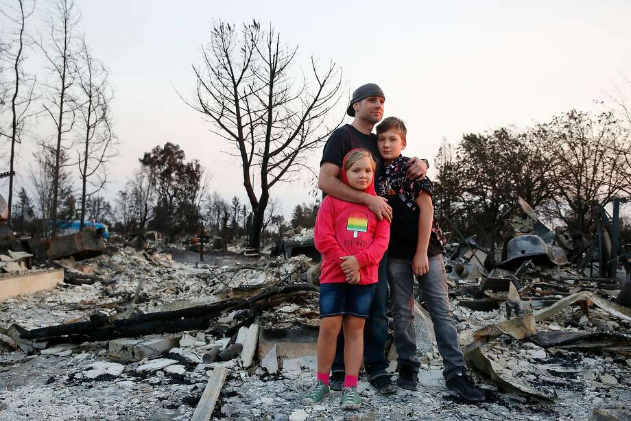 Jimmie Allen (center) stands with his children Miley Allen (left), 9, and Jaden Frank, 13, on the ashes that were their home in Coffey Park in Napa. | Photo: Lea Suzuki, The Chronicle
