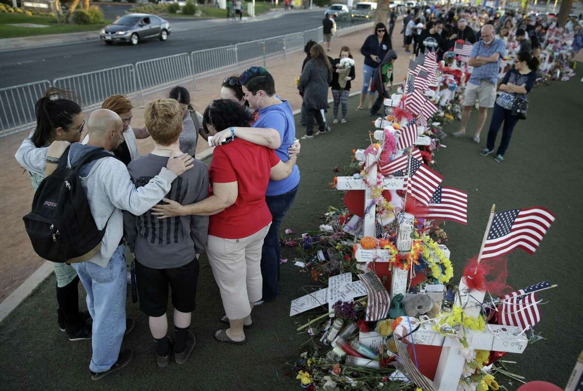 People pray Oct. 9 at a makeshift memorial for victims of the mass shooting in Las Vegas. Gunman Stephen Paddock opened fire Oct. 1 from a room at the Mandalay Bay resort and casino, on an outdoor country music concert, killing dozens and injuring hundreds. Times like these should not be politicized.