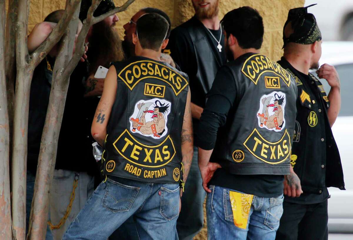 Bikers congregate against a wall while authorities investigate a Twin Peaks restaurant on May 17, 2015, in Waco, Texas, after gunfire erupted between rival biker gangs - Bandidos and Cossacks.Scroll through to see more images from the shootout