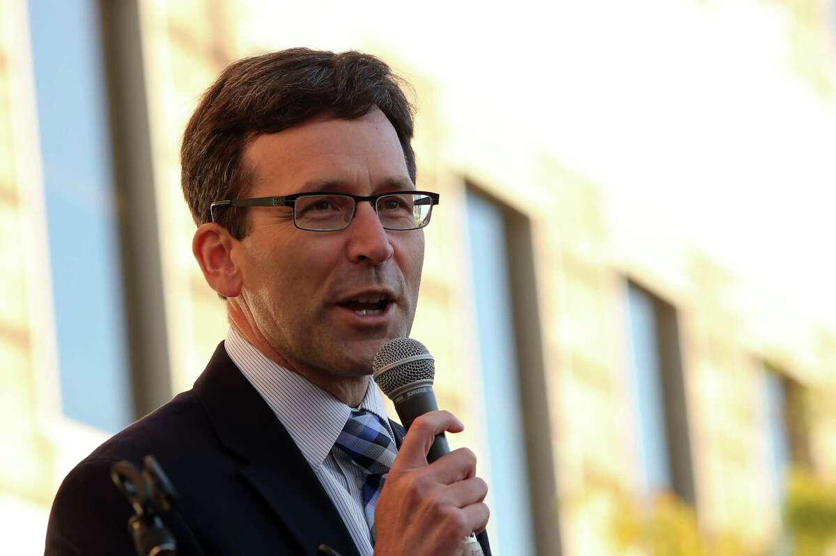 Washington Attorney General Bob Ferguson speaks to crowds outside of the Hyatt Regency Bellevue during a protest against the policies of Secretary of Education Betsy DeVos who spoke at the Washington Policy Center's annual gala, Friday evening, Oct. 13, 2017.