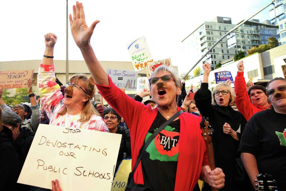People cheer as Washington Attorney General Bob Ferguson speaks outside of the Hyatt Regency Bellevue to protest a speech by Secretary of Education Betsy DeVos at the Washington Policy Center's annual gala, Friday, Oct. 13, 2017.