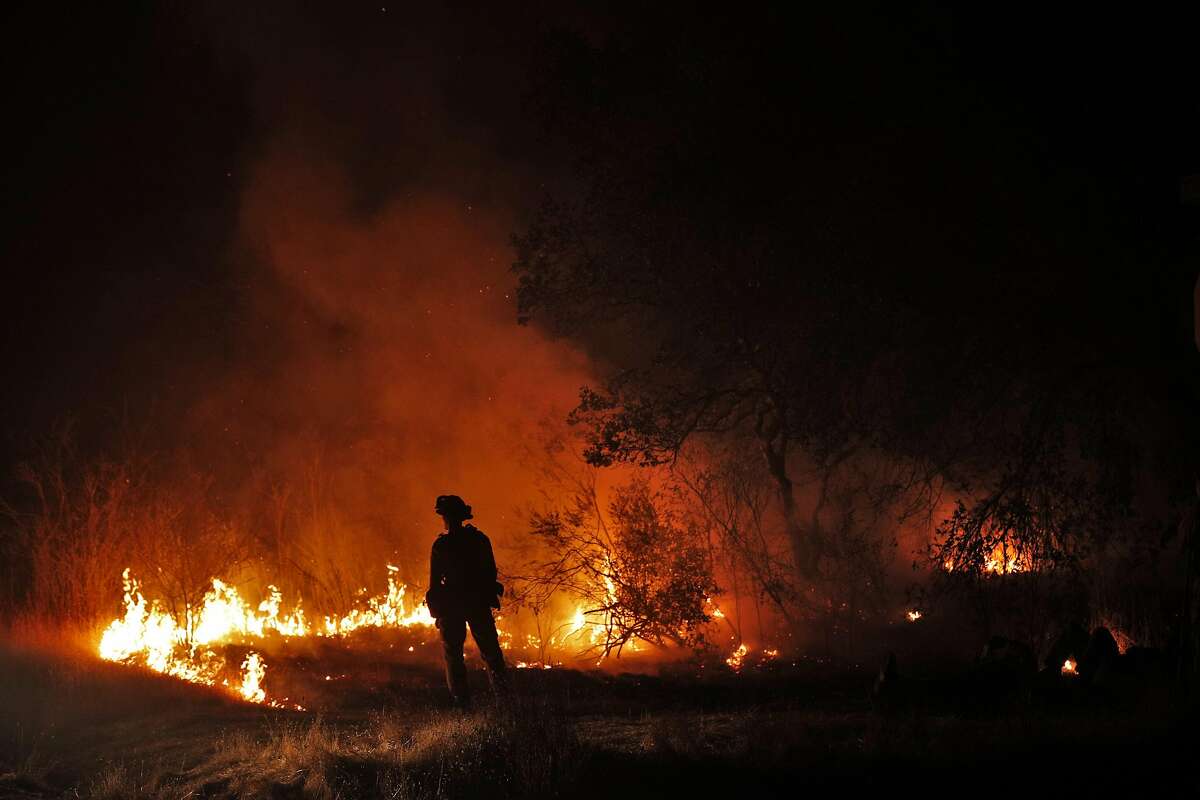 A firefighers keeps an eye on a flare up on Lovall Valley Road as crews continue to monitor several wildfires near Sonoma, Calif., on Friday, October 13, 2017. Emergency personnel were deployed to the perimeter of several fires as the threat of gusting winds had them worried that the fires would grow overnight.