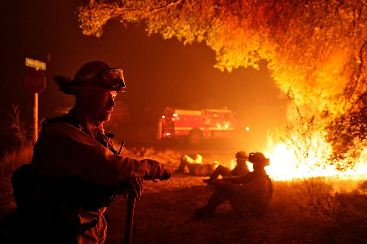 Firefighter Kevin Weaver from Station 1 in Petaluma keeps an eye on a flare up on Lovall Valley Road as crews continue to monitor several wildfires near Sonoma, Calif., on Friday, October 13, 2017. Emergency personnel were deployed to the perimeter of several fires as the threat of gusting winds had them worried that the fires would grow overnight.
