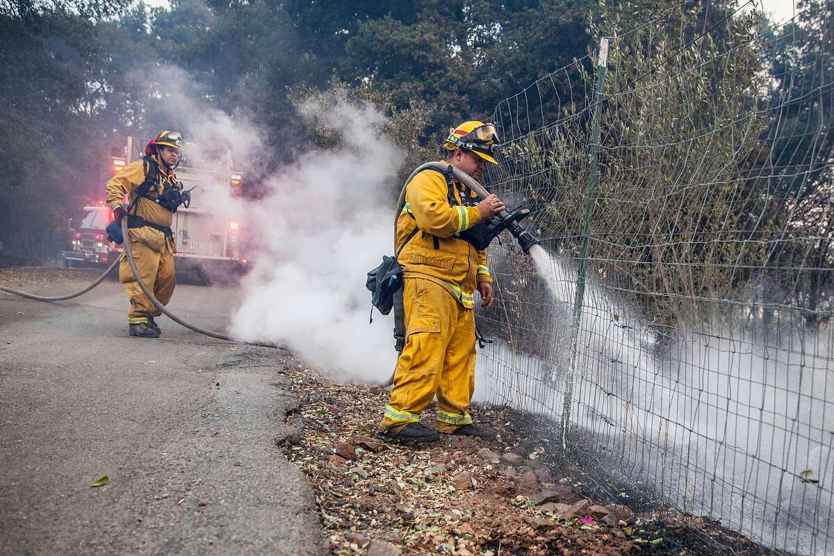 Fire fighters work on putting out hotspots at a home off Lovall Rd in Sonoma, California, USA 14 Oct 2017.