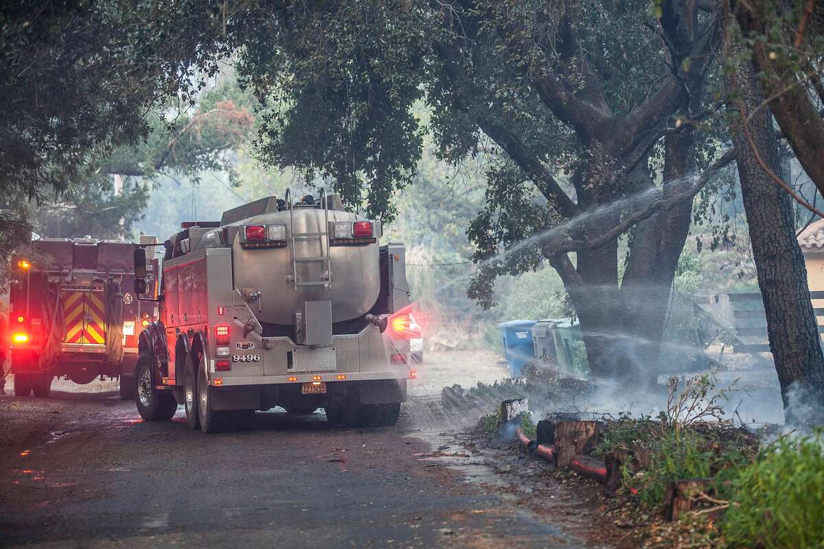 A water tender sprays water along the roadside to put out hot spots along the 1100 block of Castle Rd in Sonoma, California, USA 14 Oct 2017.