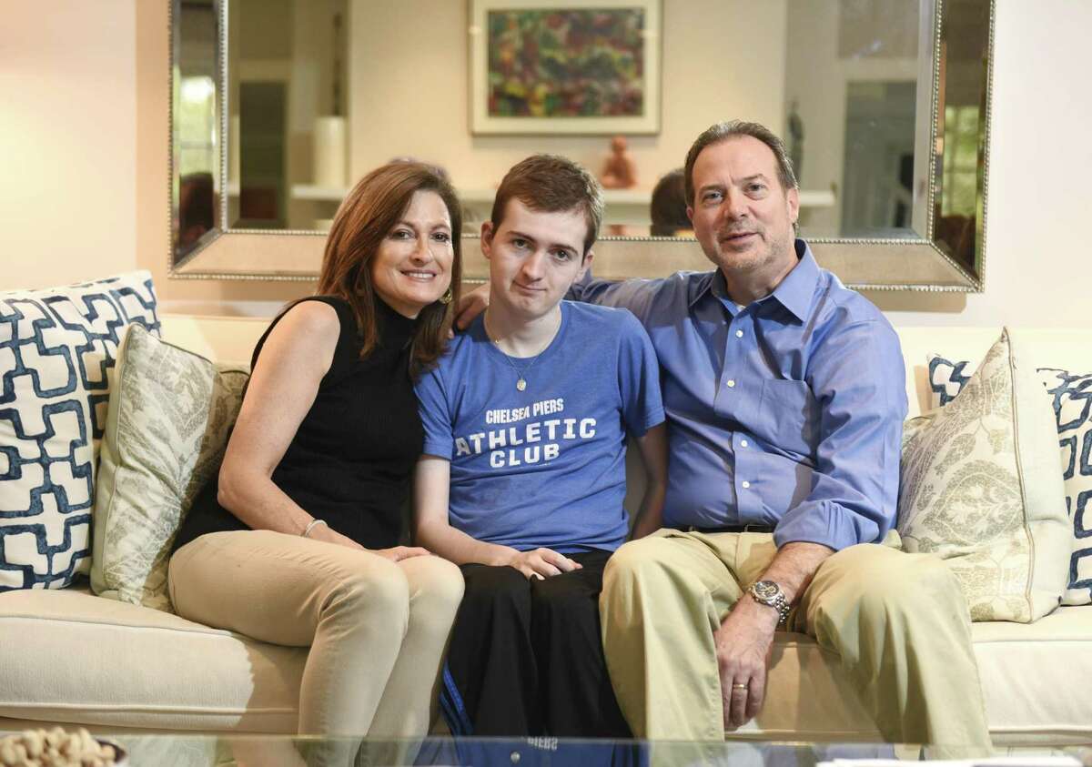 Andrea and Phil Marella pose with their son, Andrew, 18, at their home in Greenwich, Conn. Wednesday, Oct. 11, 2017. Andrew has a rare progressive genetic disorder called Niemann-Pick disease type C (NPC), which took the life of his sister, Dana, in 2013. The Marella's non-profit Dana?’s Angels Research Trust (DART), raises money to research the disease and is holding a benefit concert featuring country music star Hunter Hayes at The Palace Theatre in Stamford on Nov. 11.