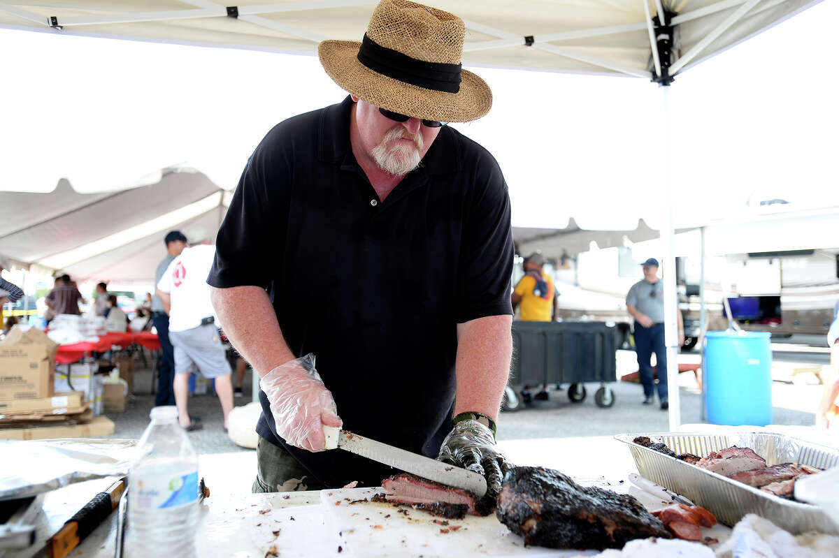 Keith Wilson cuts brisket during the Beaumont Professional Firefighters Local 399's "Beaumont Strong" barbecue sale on Saturday. The fire union held the event to raise money for city employees who didn't have flood insurance when Tropical Storm Harvey damaged their property. Photo taken Saturday 10/14/17 Ryan Pelham/The Enterprise