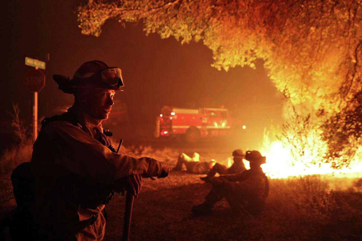 Firefighter Kevin Weaver from Station 1 in Petaluma keeps an eye on a flare up on Lovall Valley Road as crews continue to monitor several wildfires near Sonoma, Calif., on Friday, October 13, 2017. Emergency personnel were deployed to the perimeter of several fires as the threat of gusting winds had them worried that the fires would grow overnight.