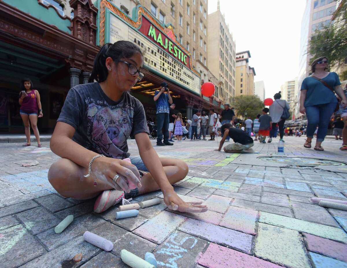 Desiree Benavides, 13, works on her art during the Artpace Chalk It Up event along Houston Street in downtown San Antonio on Saturday, Oct. 14, 2017. Local artists teamed up with the public to create chalk murals and standalone pieces on the sidewalk. Music and food added to the festive atmosphere of the event.