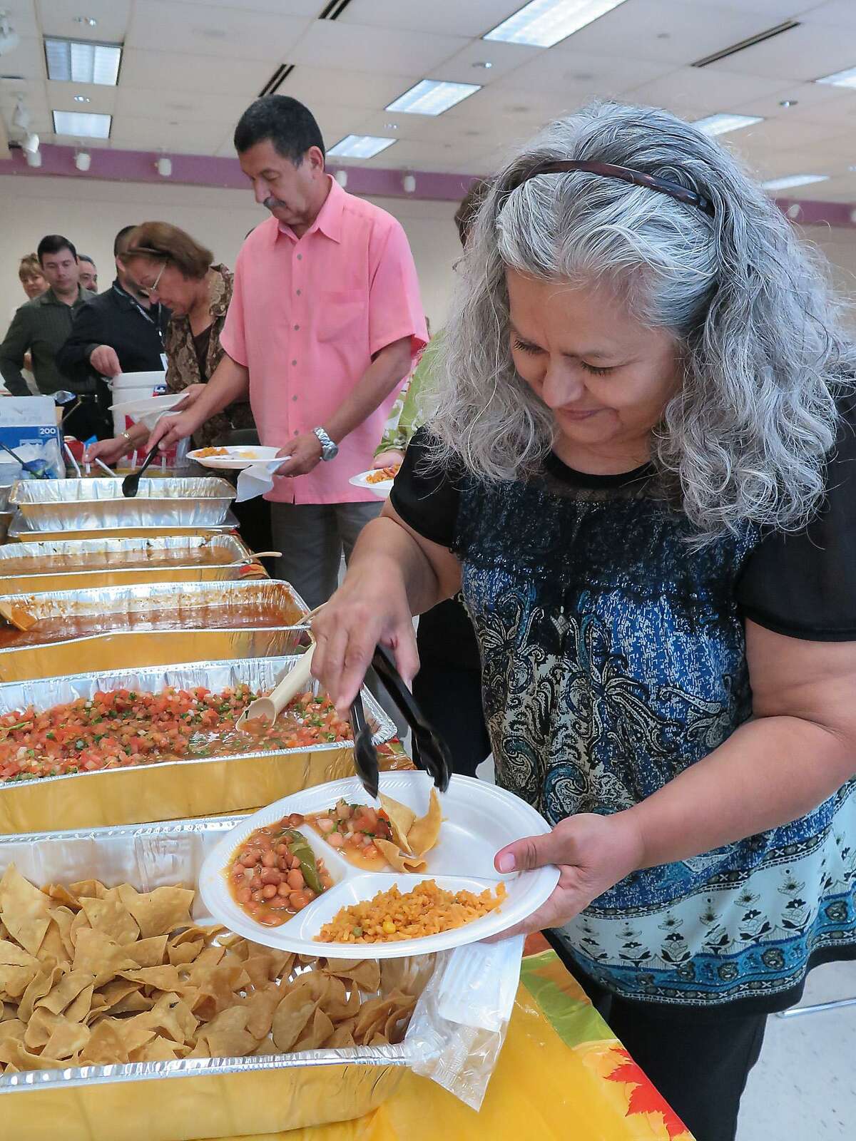 Josefina Luera adds some tortilla chips to her plate of rice and beans as she participates in the Laredo Regional Food Bank's 33rd Annual Rice and Beans Hunger Luncheon in commeration of World Food Day. The event was held Thursday at the Laredo Public Linrary Community Room.