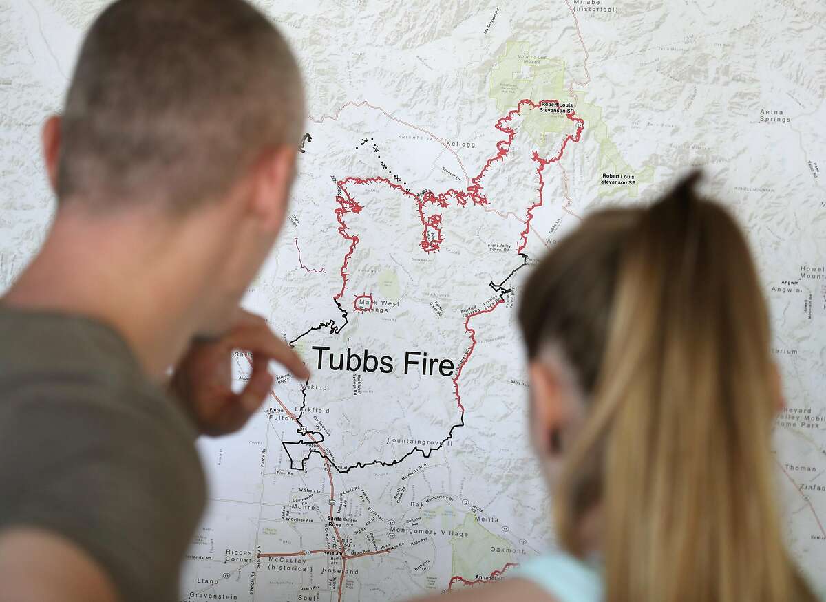 Santa Rosa residents Johnny Smith and Katie Chapman look at a map of the Wine Country fires during a Sonoma County Fire Response and Recovery community meeting at Santa Rosa High School in Santa Rosa, Calif., on Saturday, October 14, 2017.