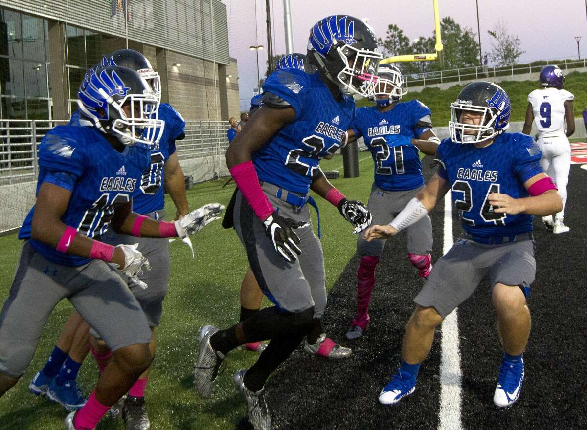 New Caney defensive back Jaylen Neal, center, celebrates with teammates after returning an interception for a 41-yard touchdown during the second quarter of a District 21-5A high school football game against Humble at Texan Drive Stadium on Saturday, Oct. 14, 2017, in New Caney.