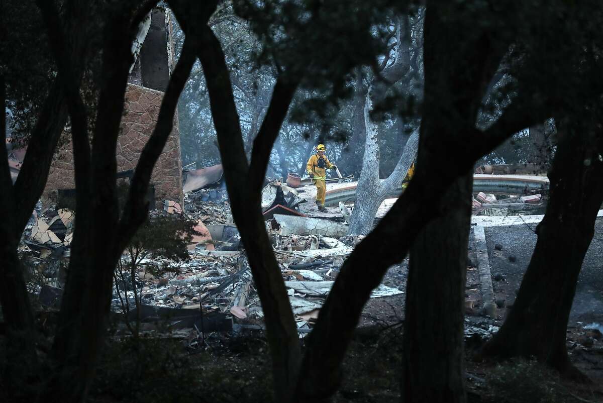 A firefighter walks through what remains of a large home that burned in The Ranch subdivision in Sonoma, Calif., on Saturday, October 14, 2017.