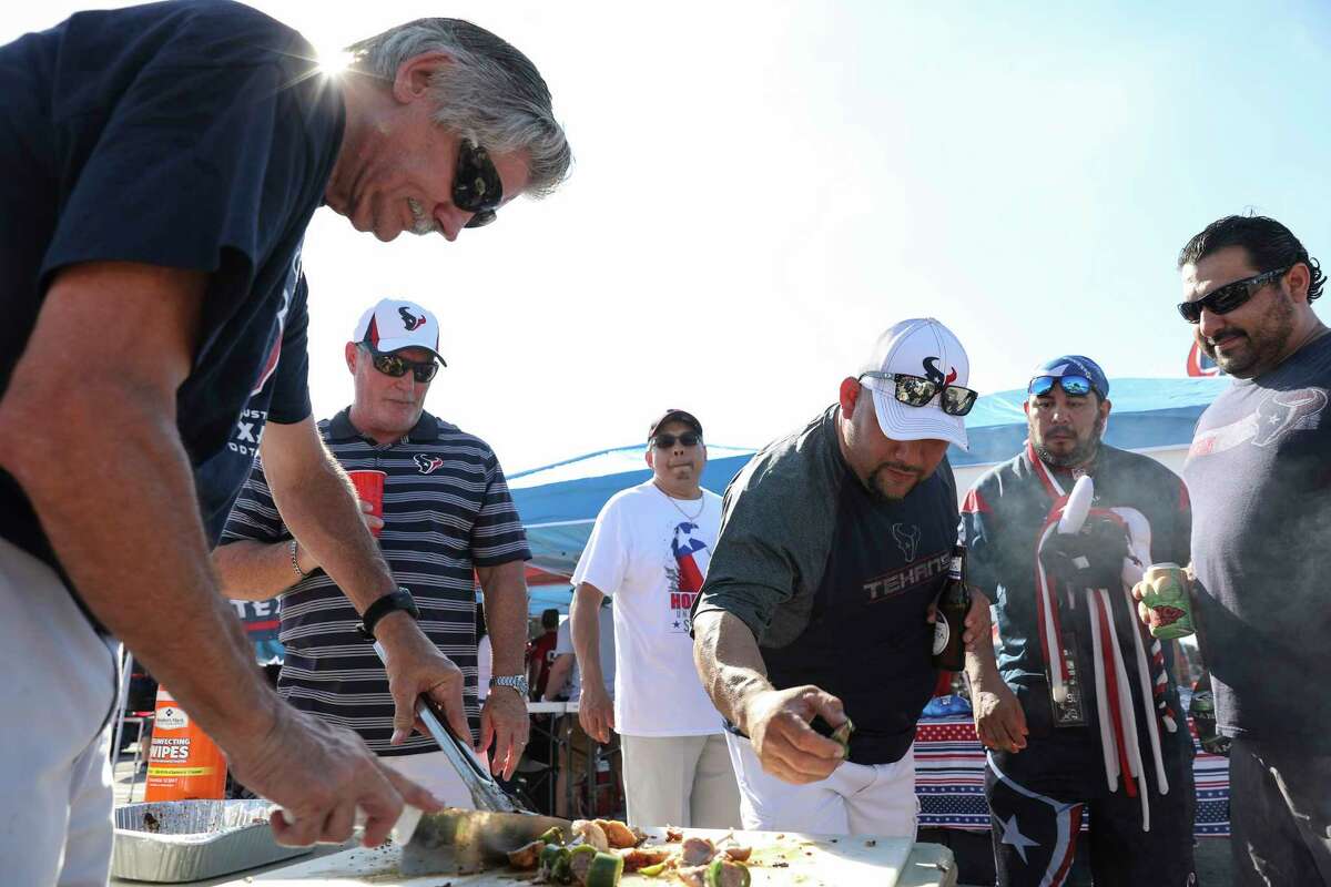 Houston Texans tailgaters try some smoked stuffed chicken-wrapped-stuffed-jalapeno made b y pitmaster Al Stansbury outside of NRG Stadium before the team takes on Cleveland Browns for a NFL game Sunday, Oct. 15, 2017, in Houston.