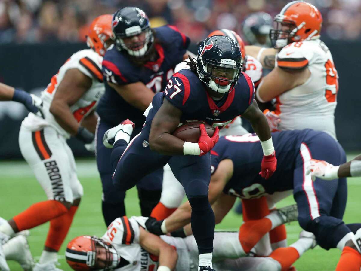 Houston Texans running back D'Onta Foreman (27) carries the ball and runs pass through a pack of Cleveland Browns players during the third quarter of an NFL football game at NRG Stadium on Sunday, Oct. 15, 2017, in Houston.
