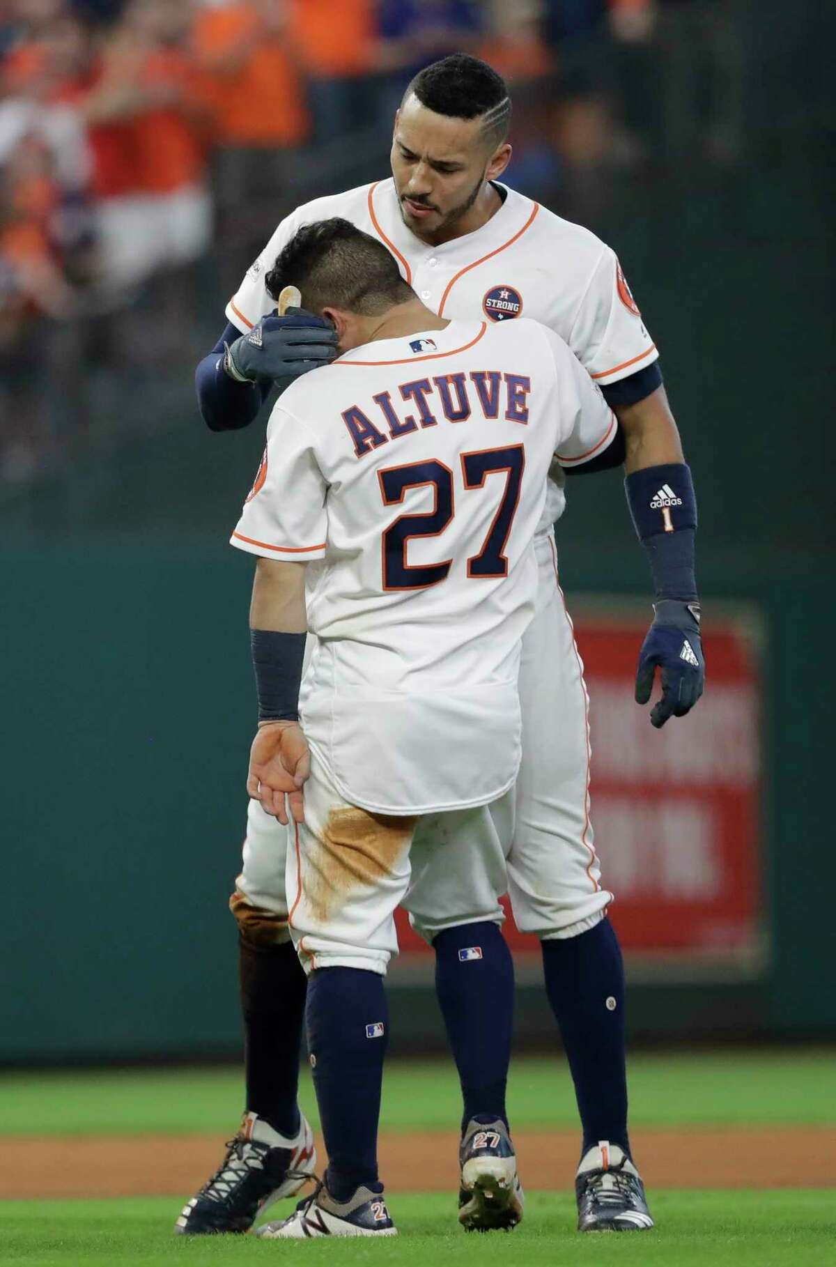 Houston Astros' Jose Altuve hugs Carlos Correa after scoring the game-winning run during the ninth inning of Game 2 of baseball's American League Championship Series against the New York Yankees Saturday, Oct. 14, 2017, in Houston. The Astros won 2-1 to take a 2-0 lead in the series. (AP Photo/David J. Phillip)