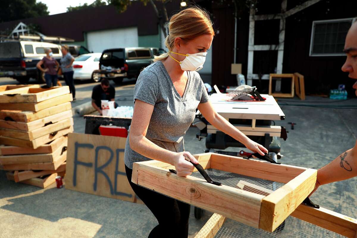 Brittany Perry hands out a free ash sifter to a fire victim at Pacific Coast Custom Interiors in Santa Rosa, Calif., on Sunday, October 15, 2017.
