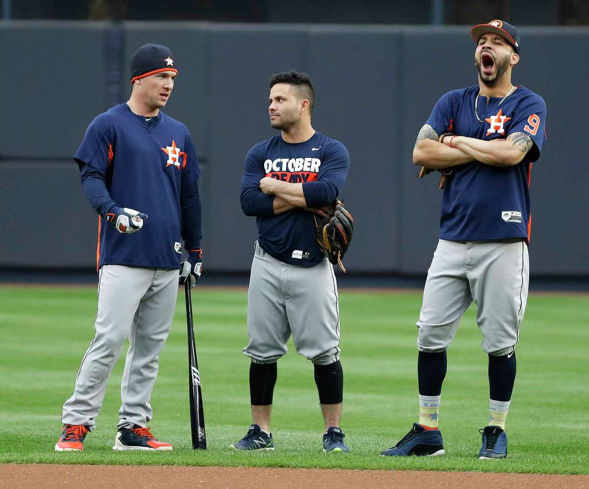 Astros third baseman Alex Bregman, left, appears to have the attention of teammate Jose Altuve, center, but Marwin Gonzalez, right, has his mind on other things during the Sunday workout.