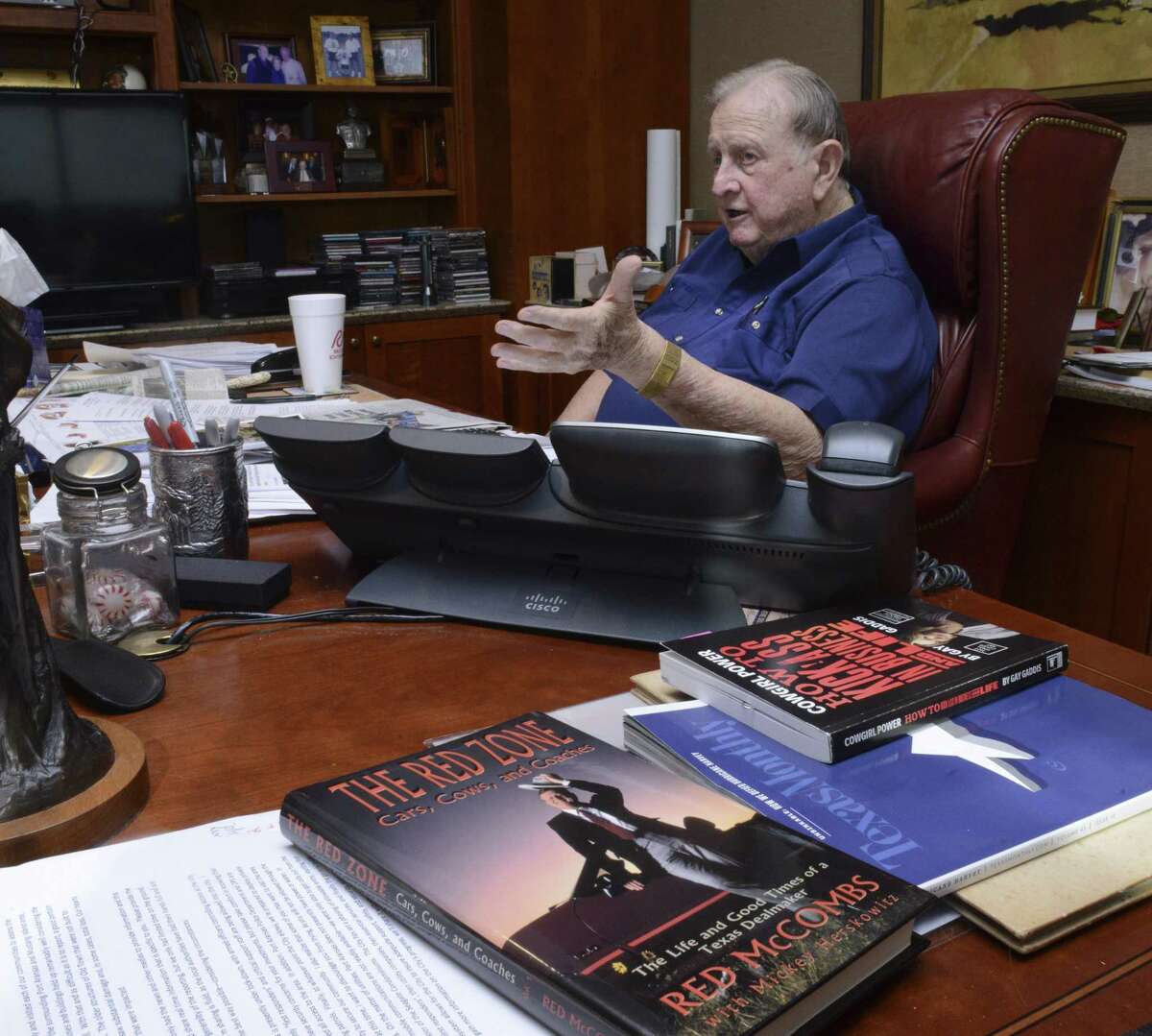San Antonio businessman Red McCombs will soon turn 90 years old. He said that he has never considered retiring. A copy of his book, "The Red Zone," is on his desk at McCombs Enterprises in San Antonio.