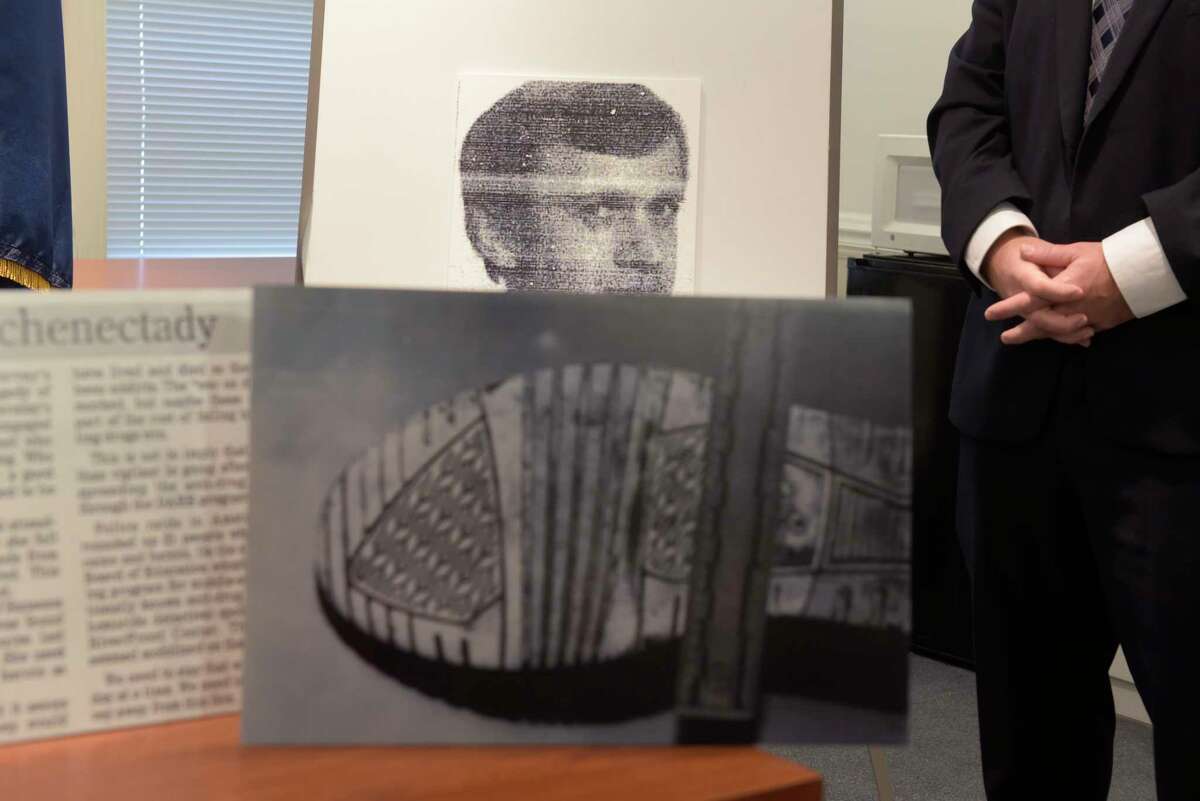 A photograph of Stanislaw Maciag is seen in the background at a press conference on Monday, Oct. 16, 2017, in Schenectady, N.Y. In the foreground is an investigation photograph of the bottom of a sneaker worn by Maciag. (Paul Buckowski / Times Union)