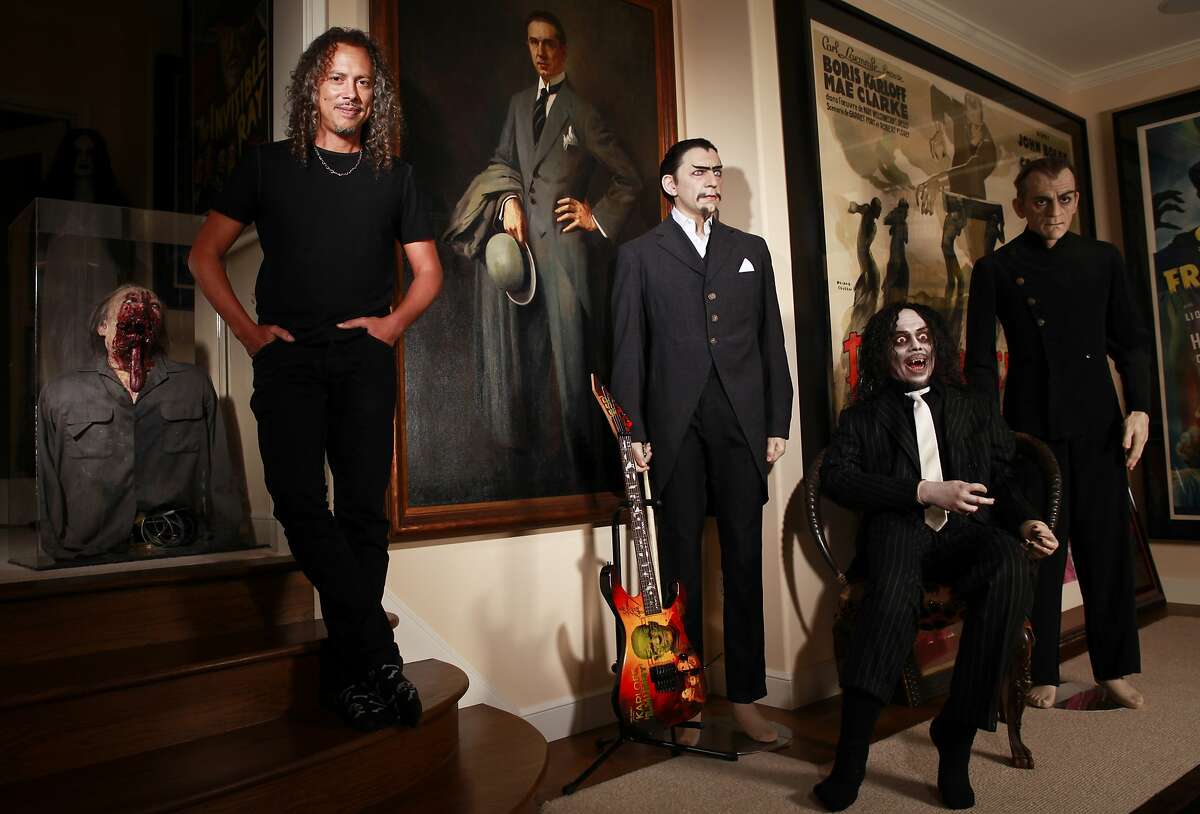 Kirk Lee Hammett, guitarist for Metallica and longtime horror film fanatic, is coming out with a book, "Too Much Horror Business - The Kirk Hammett Collection." Hammett is seen with part of his horror film collection in his San Francisco, Calif., home on Thursday, Aug. 23, 2012. Pieces in his collection include from left a zombie from the film, "Day of the Dead," a painting of Bela Lugosi which hung in Lugosi's home, a statue of Lugosi wearing a suit from the film, "White Zombie," and a statue of Boris Karloff wearing an outfit from the film, "The Black Cat." Seated is a statue of Hammett.