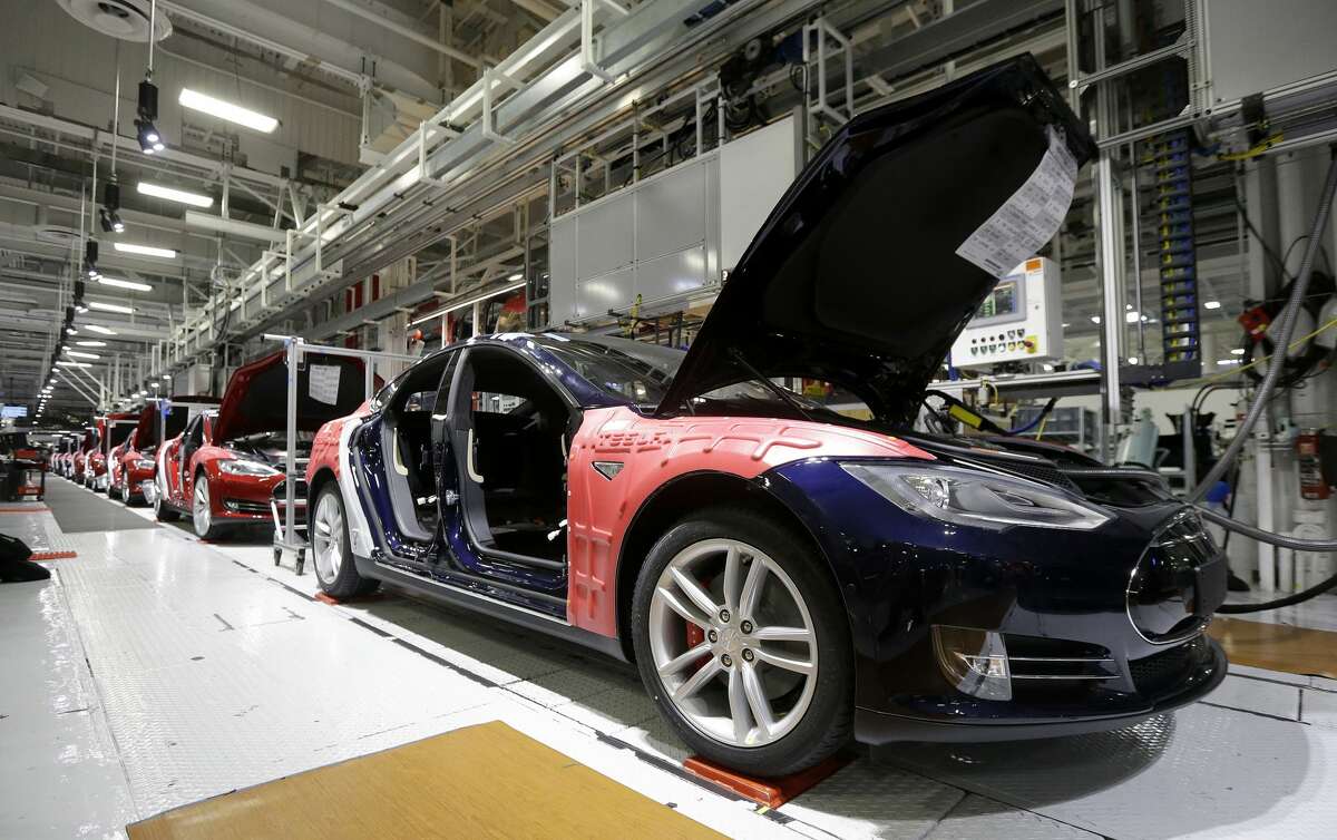 FILE - In this May 14, 2015, file photo, Tesla Model S cars are shown in the Tesla factory in Fremont, Calif. Tesla?’s second-quarter deliveries surged 52 percent to set a company record exceeding 11,000 vehicles, the electric car maker said Thursday, July 2, 2015. (AP Photo/Jeff Chiu, File)