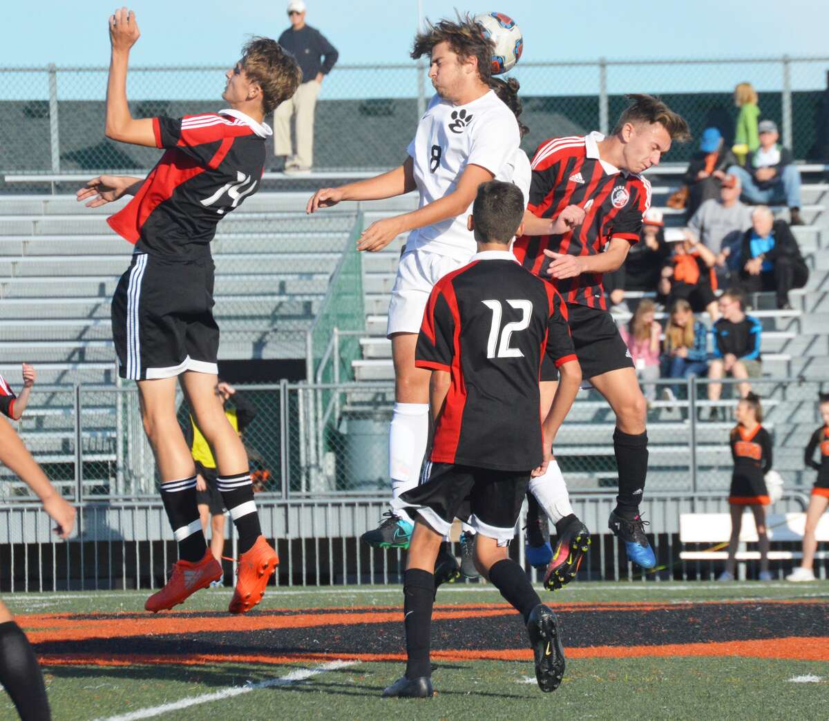 Edwardsville midfielder Devin Parker, center, wins a 50-50 ball with a header against three Granite City defenders during first-half action of the Class 3A Edwardsville Regional semifinals inside the District 7 Sports Complex on Tuesday.