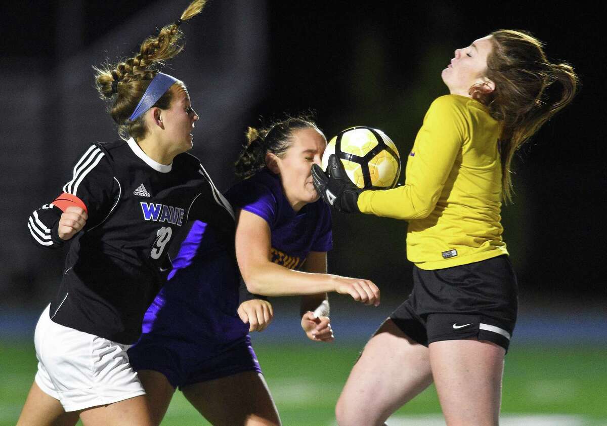 Westhill goalie Niamh Keogh makes a save as she collides with teammate Erica Shaulson (22) and Darien Emily DeNunzio (19) in a FCIAC girls soccer game in Darein, Connecticut on Tuesday, Oct.17, 2017.