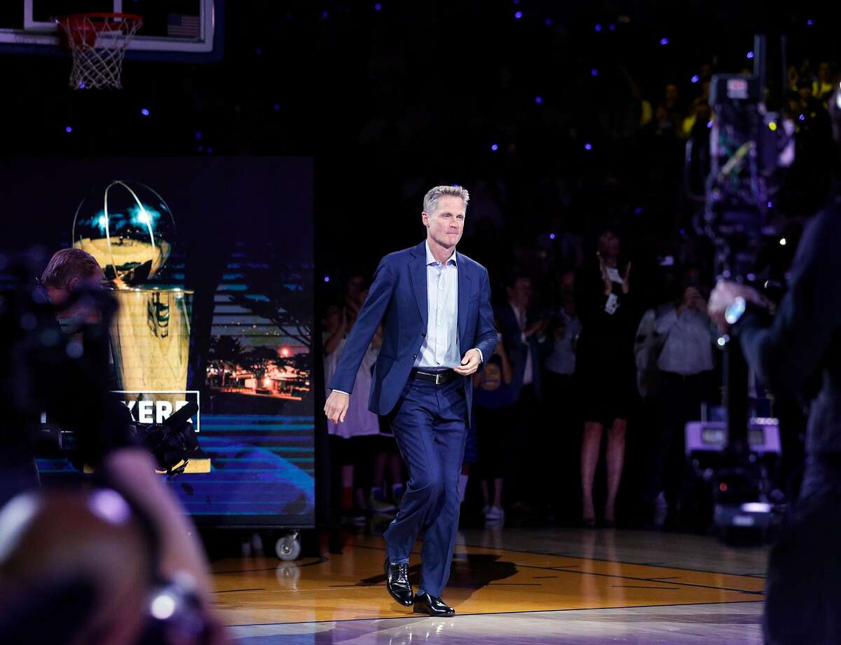 Head Coach Steve Kerr approaches center court to recieve his championship ring before the Golden State Warriors played the Houston Rockets at Oracle Arena in Oakland, Calif., Tuesday, October 17, 2017.