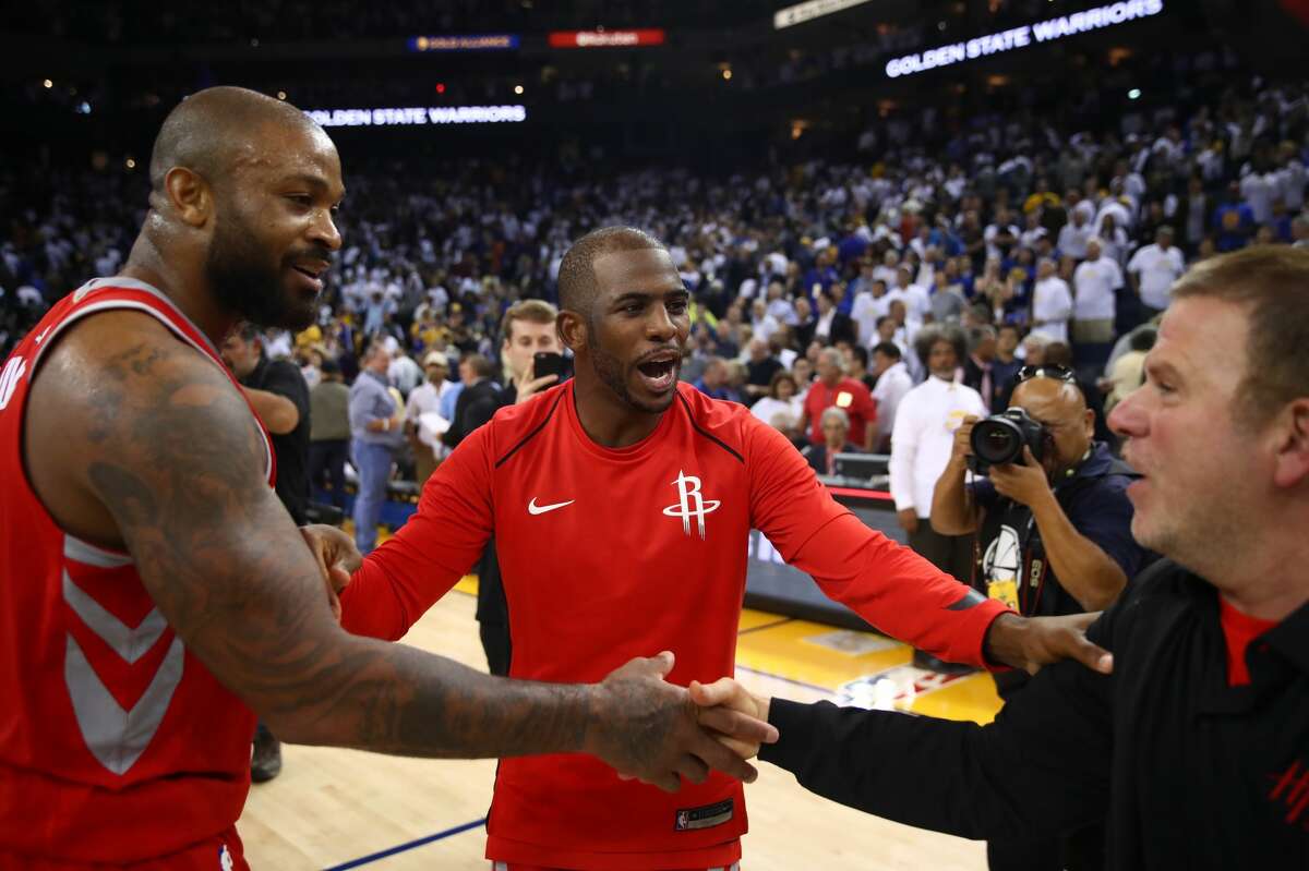 OAKLAND, CA - OCTOBER 17: PJ Tucker #4, Chris Paul #3 and team owner Tilman Fertitta of the Houston Rockets celebrate after defeating the Golden State Warriors 122-121 in their NBA game at ORACLE Arena on October 17, 2017 in Oakland, California. NOTE TO USER: User expressly acknowledges and agrees that, by downloading and or using this photograph, User is consenting to the terms and conditions of the Getty Images License Agreement. (Photo by Ezra Shaw/Getty Images)