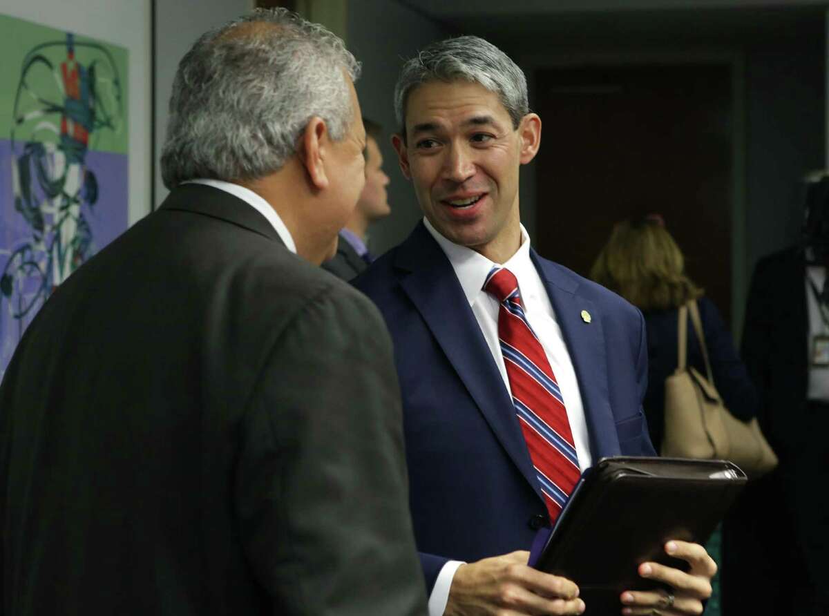 San Antonio Mayor Ron Nirenburg, right, talks with SAWS CEO and President Robert Puente after SAWS directors proposed a rate hike on Oct. 18, 2017.