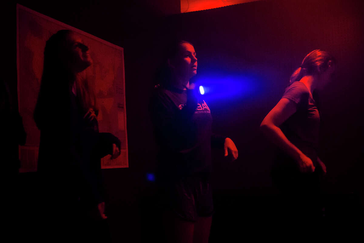 Jade Dawson, 13, left, Sydney Miller, 13, center, and Rachel Dostal, 13, right, look for clues as they walk through the Zombie Escape Fear Fest haunted attraction on Friday, Oct. 13 in Midland. (Katy Kildee/kkildee@mdn.net)