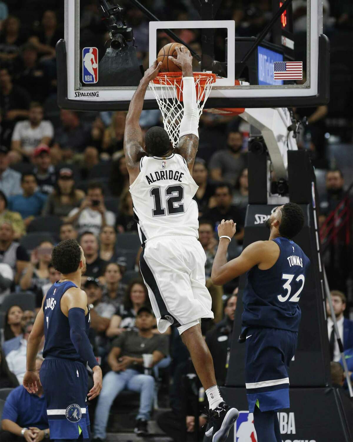 Spurs' LaMarcus Aldridge (12) dunks against Minnesota Timberwolves' Karl-Anthony Towns (32) and Tyus Jones (01) in the fourth at the AT&T Center on Wednesday, Oct. 18, 2017. Spurs defeated the T'Wolves, 107-99. (Kin Man Hui/San Antonio Express-News)