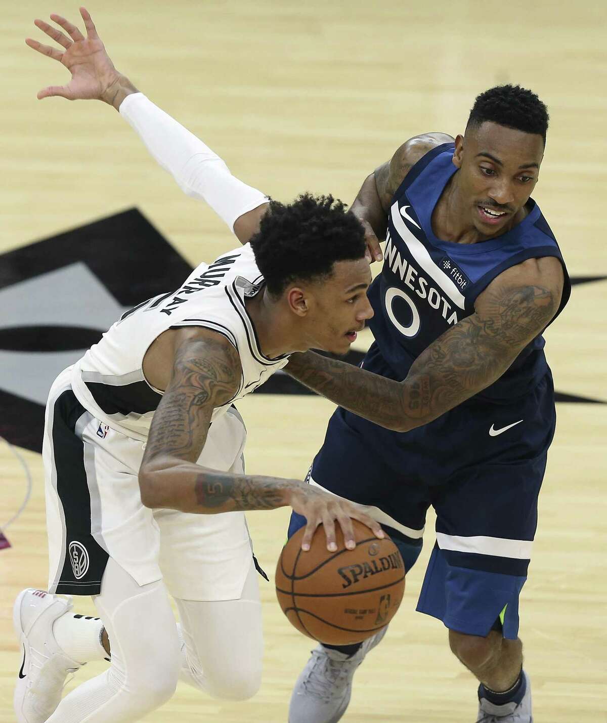 Dejounte Murray gets by Jeff Teague as the Spurs play Minnesota in the season opener at the AT&T Center on October 18, 2017.
