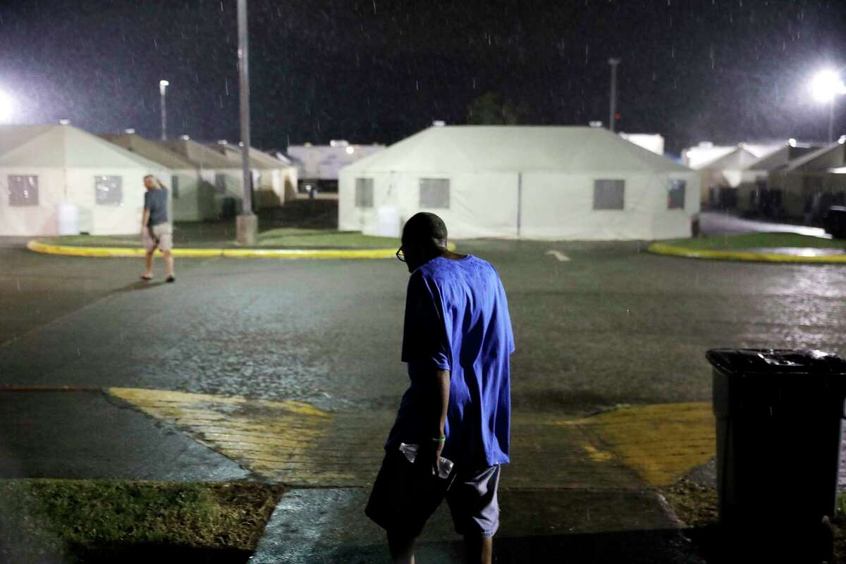 Arthur Shields walks through a temporary shelter encampment where he's been living for nearly a month since hurricane Harvey damaged their homes in Port Arthur, Texas, Wednesday, Sept. 27, 2017. Jefferson County was drowned by more than 60 inches of rain during Hurricane Harvey, the most rainfall ever recorded in a single storm in the nation's history, according to preliminary data from the National Weather Service. (AP Photo/David Goldman)