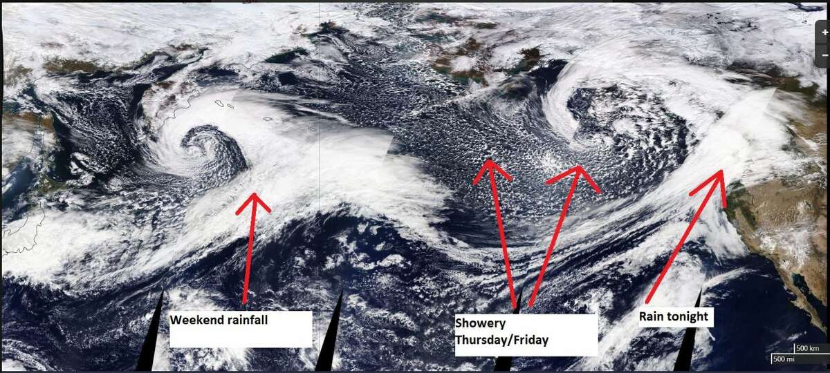 A satellite image from early Thursday shows several weather systems moving across the Pacific toward the Pacific Northwest.