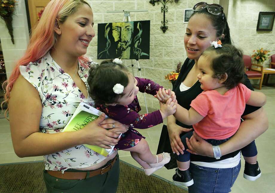 Victoria Ortiz, left, lets her daughter Gracie Guajardo play with her sister Velma Ortiz's daughter Julissa Rodriguez, right, following a Child Dedication service at The Salvation Army Center for Worship and Service. Sunday, Sept. 17, 2017. Photo: Bob Owen, San Antonio Express-News / ©2017 San Antonio Express-News