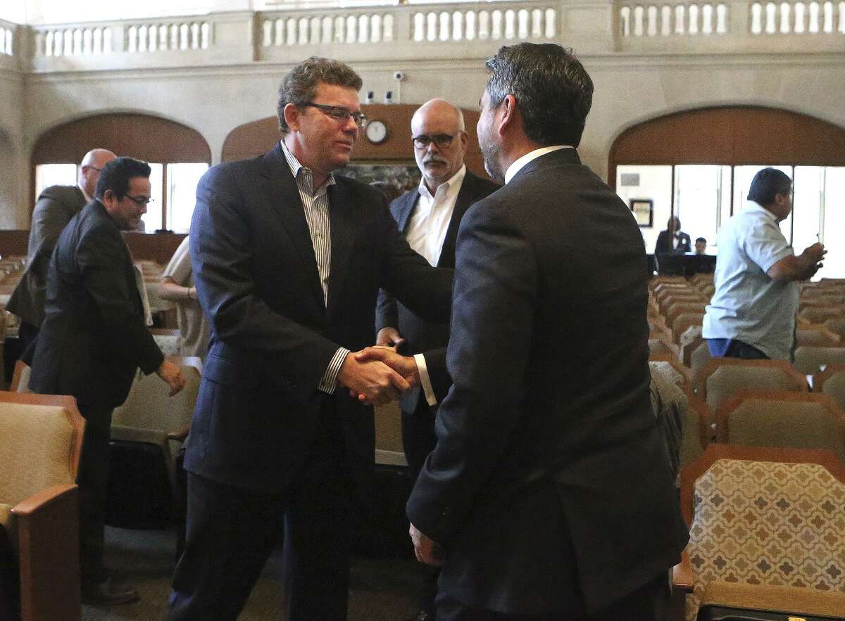 Credit Human President and CEO Stephen Hennigan (center, foreground, striped shirt) shakes hands Thursday October 19, 2017 with San Antonio city councilman Roberto Trevino (right, foreground, facing away) at city council chambers after tax abatements and other incentives were granted for Credit Human. Standing between them (background) is Bill Shown of Silver Ventures. Formerly known as San Antonio Credit Union, Credit Human will be moving to a new location at The Pearl.